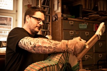 Thomas Ochs, Gitarrenbaumeister in Kemmern bei Bamberg arbeitet in seiner Werkstatt.
Gezeigter Arbeitsgang: Ränderwickeln - Das Anbringen der Randeinlagen erfolgt in traditioneller Weise.