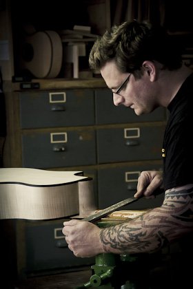 Portrait des Gitarrenbaumeisters Thomas Ochs in seiner Werkstatt in Kemmern. Raspeln des Halses eines Akustik-Basses.